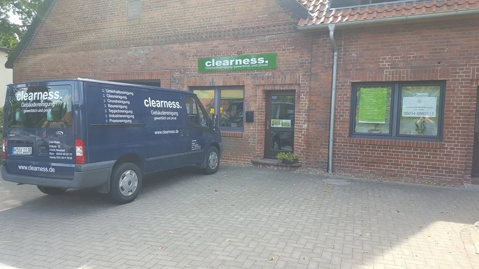Firmengebäude mit Clearness-Beschilderung und Servicefahrzeug