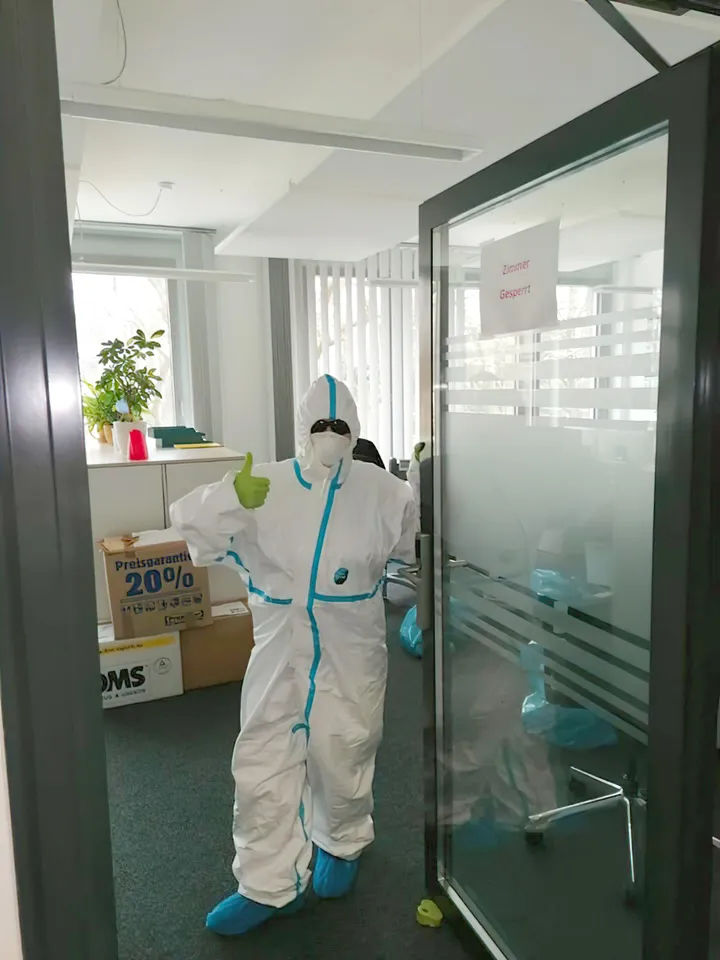 Person in Schutzkleidung in einem Büroraum